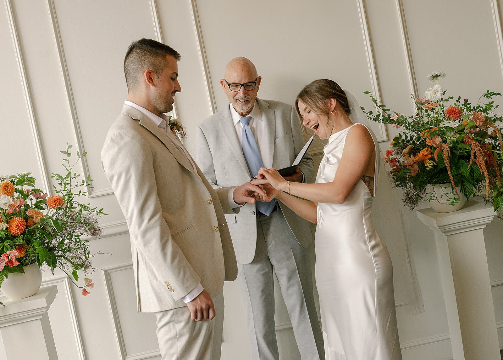 Bride and groom exchanging rings during Portland wedding with flower pillars by Kvetka