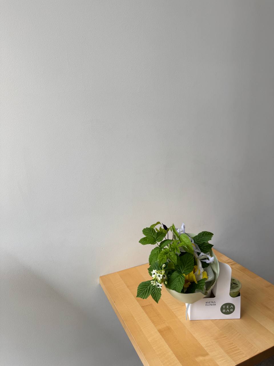 Hand holding limited-edition Mother's Day bouquet with iced matcha in collaboration between Kvetka Flower and Tea Bar in Portland, Oregon.