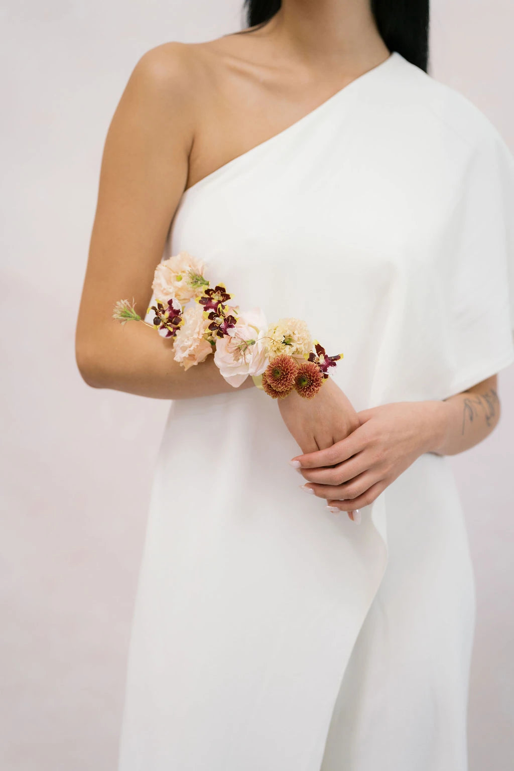 Close-up of sculptural arm corsage with lisianthus chrysanthemums and mini orchids by Kvetka Flower Portland