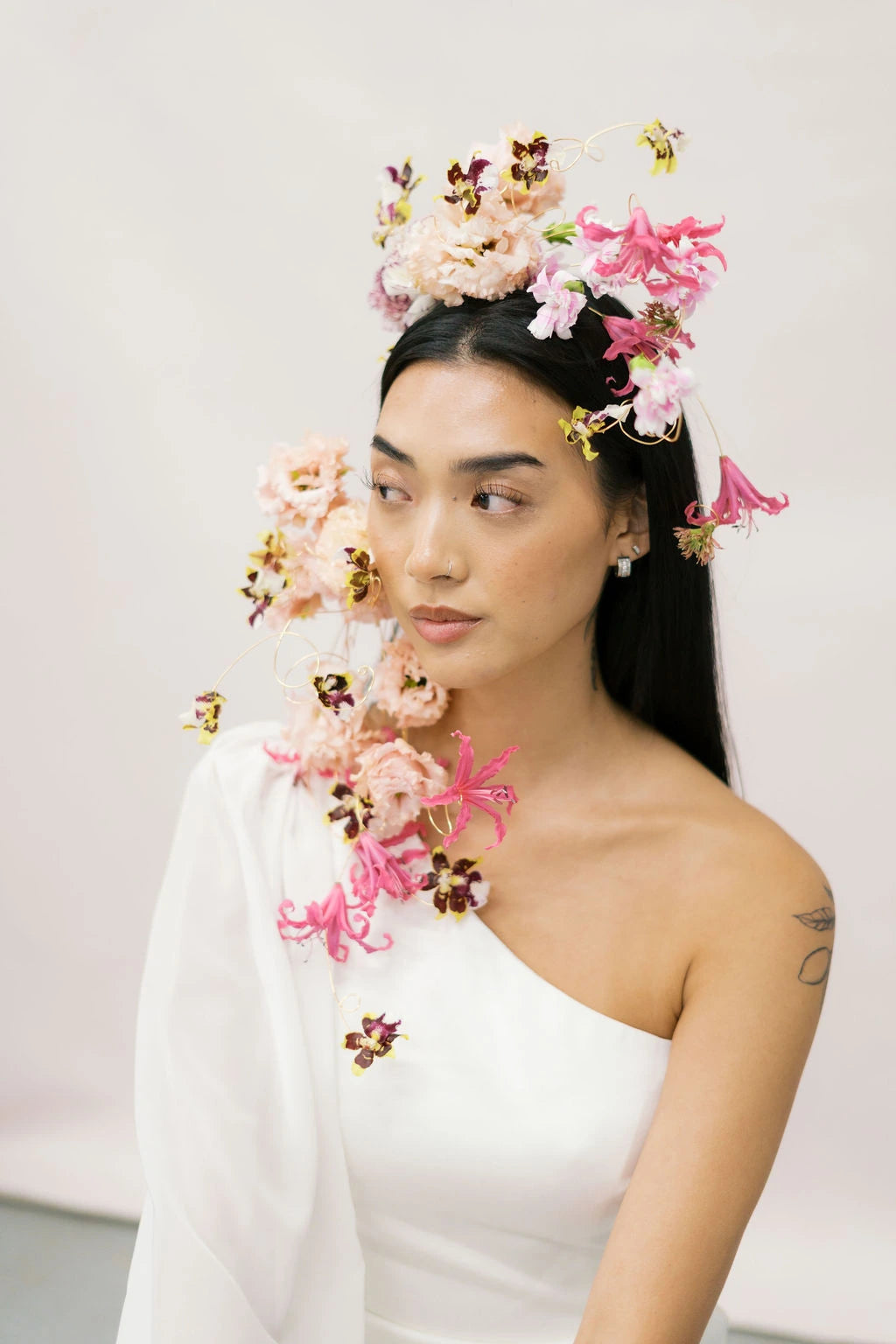 Cascading floral headpiece with mini orchids and nerine framing bride face by Kvetka Flower Portland OR