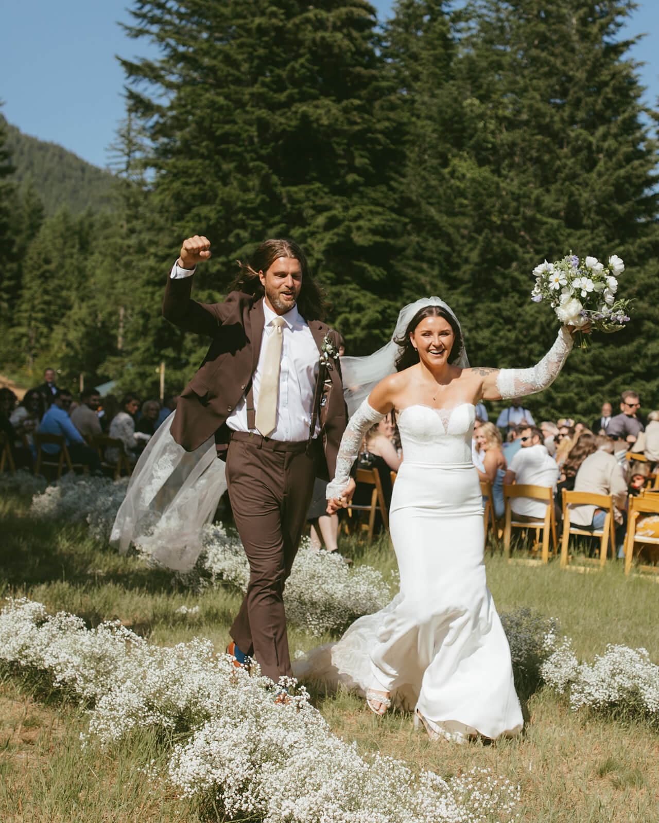 Floral aisle decor with baby’s breath and bride holding bouquet by Kvetka Flower Portland OR